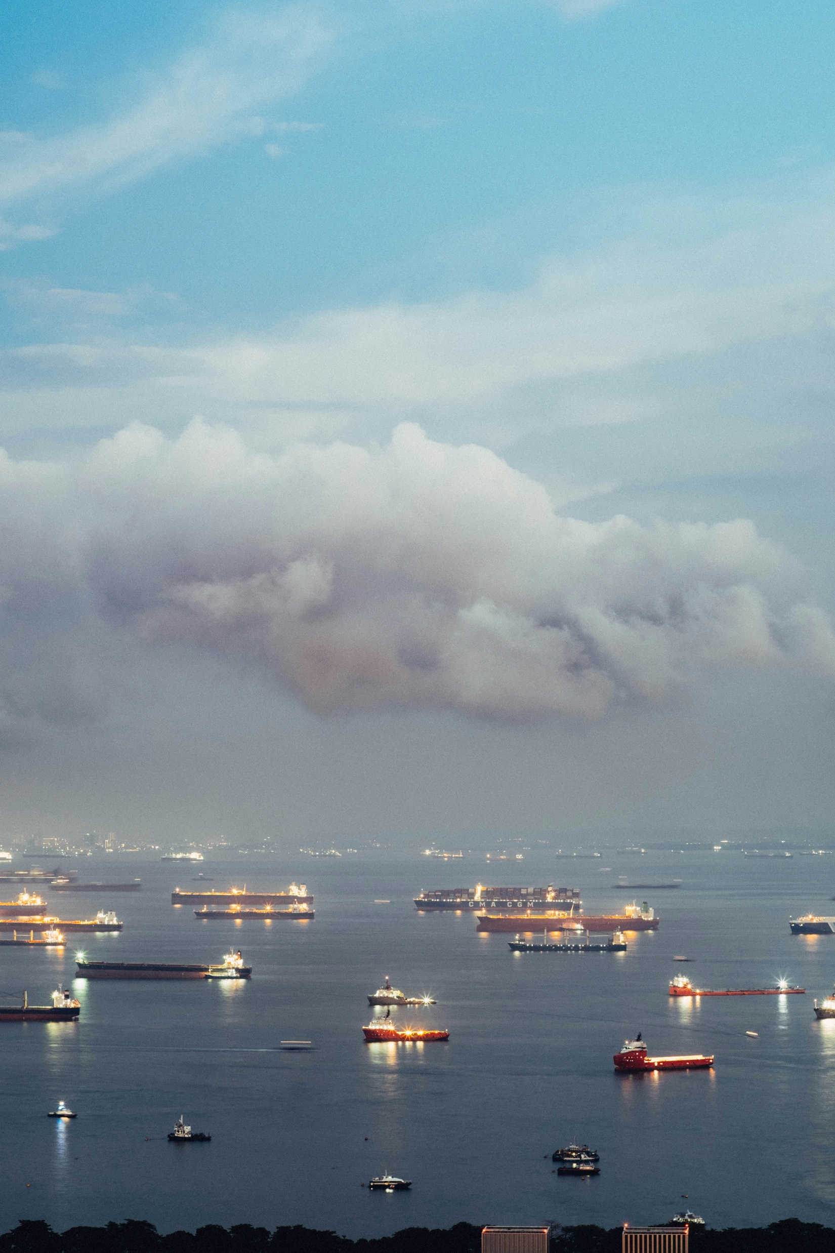 LNG tankers and cargo vessels at anchor at dusk